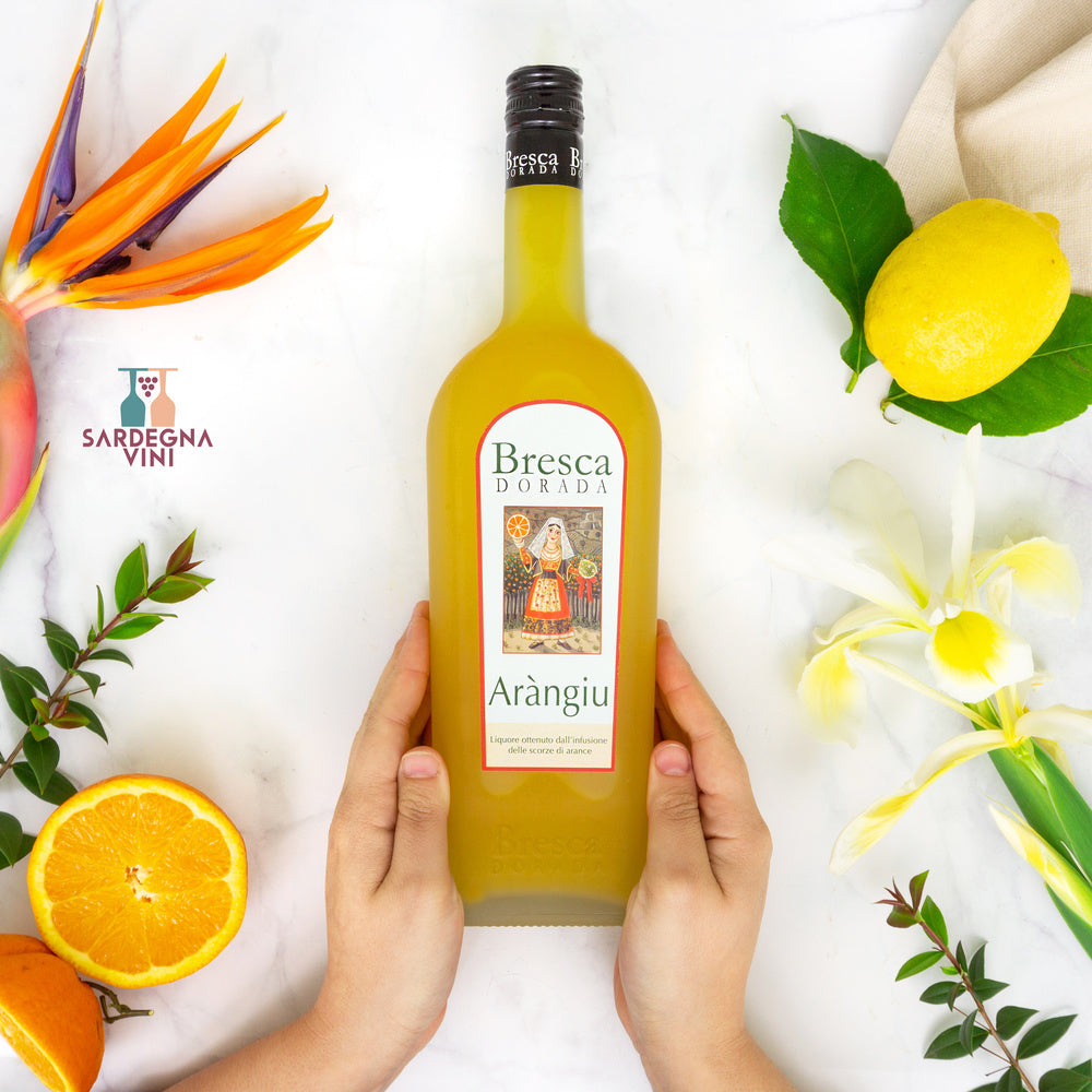 Bresca Dorada Arangiu orange liqueur bottle with a vibrant label and rich amber liquid against a neutral background.