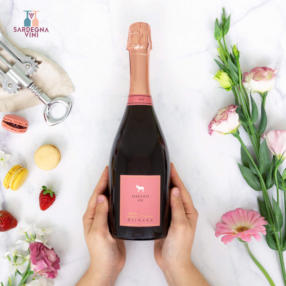 Elegant bottle of Birbante Rosé Spumante Brut by Tenuta Asinara with a sparkling pink hue and fine bubbles.