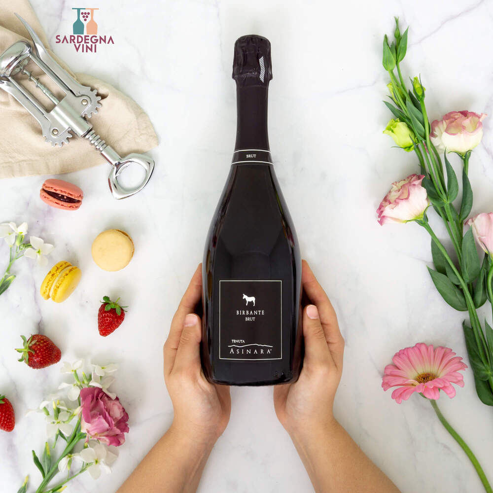 Bottle of Tenuta Asinara Birbante Spumante Brut with elegant label and sparkling wine in a clear glass.
