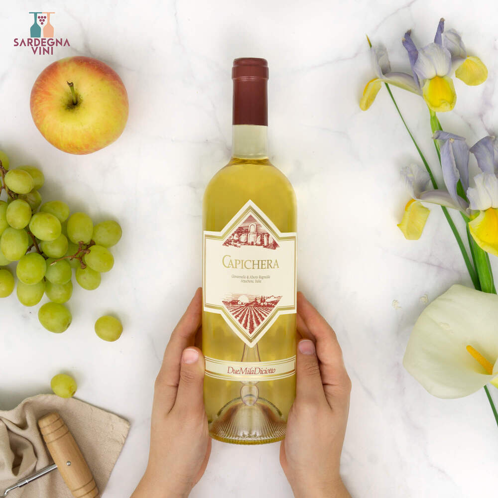 Bottle of Capichera Isola dei Nuraghi 2023 white wine with a label featuring vibrant colors and elegant design.